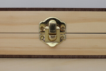 Closeup shot of golden a brass latch of a wooden box