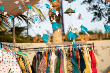 Paper-made ballerinas hanging in the air an open-air second-hand shop.