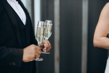 buffet, a man holds glasses of champagne in his hands