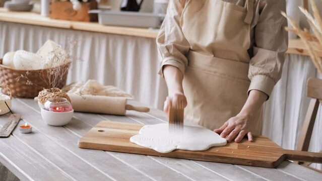 Handcraft woman master modeling cold porcelain, hands makes pattern and texture on the dough, beats it with wooden mallet, hobby for the soul scandinavian and boho style interior decor