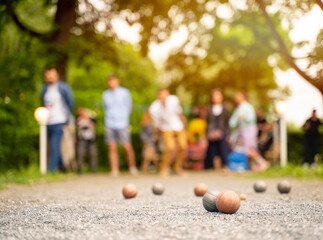 Outdoor active game friends playing petanque guy throwing a ball city park	

