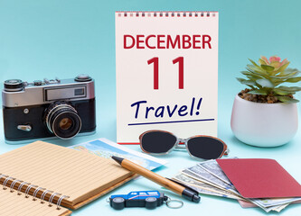 Travel planning, vacation trip - Calendar with the date 11 December glasses notepad pen camera cash passports.