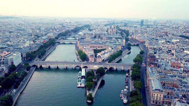 Drone flying Seine river towards Ile de la Cite with Pont Neuf bridge in foreground. Panoramic aerial view of city Paris, France.