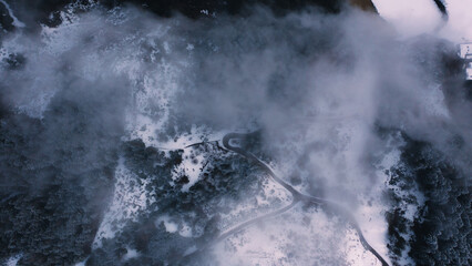 Aerial view of mountain road covered with fog during daytime in Zillertal, Tyrol, Austria.