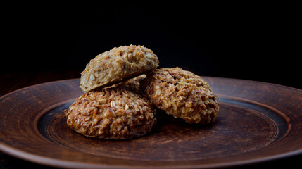 Oatmeal cookies lie on a clay plate. Rustic oatmeal cookies.