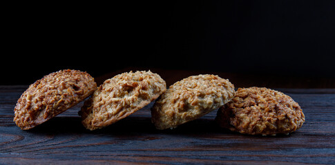 Oatmeal cookies laid out in a row on a wooden board. Rustic oatmeal cookies.