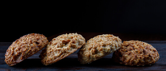 Oatmeal cookies laid out in a row on a wooden board. Rustic oatmeal cookies.