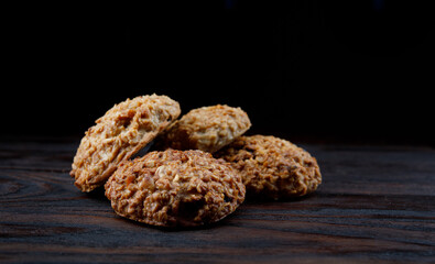 A pile of oatmeal cookies lies on a wooden board. Rustic oatmeal cookies.