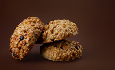 Handmade oatmeal cookies on a brown background.
