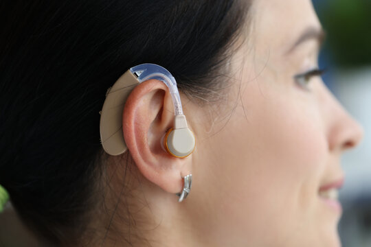 Hearing aid is on woman ear closeup