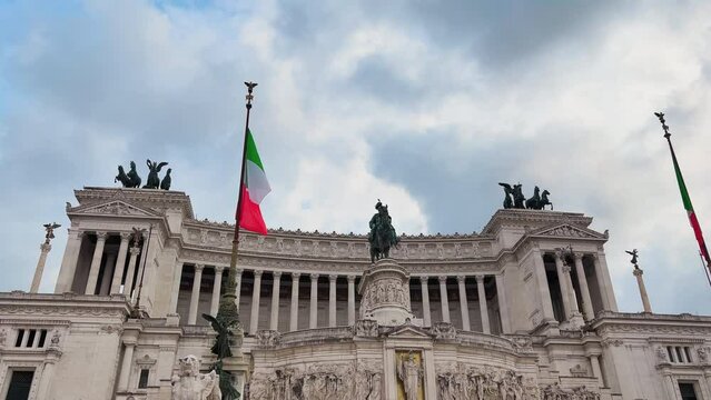 Tilt down shot of italian Altar of the Fatherland with flag against cloudy sky in Rome,Italy