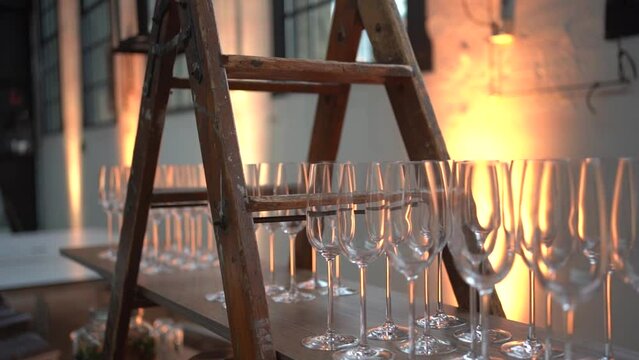 slow motion of empty champagne glasses standing on a wooden shelf at weeding
