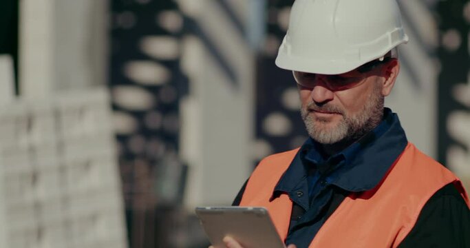 Costruction Worker using digital tablet at Construction Site