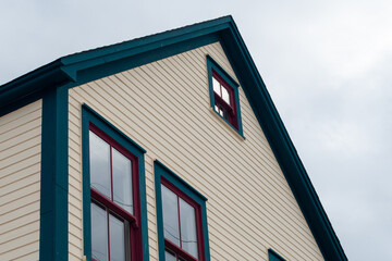 The upward view of the exterior roof section of a wooden vintage building. The colorful yellow,...