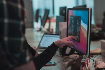 A photo of three men staring intently at a computer while sitting in a modern office. Selective focus 