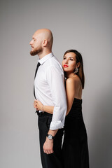 Lovely female hugging tall bald bearded hipster in white shirt and tie.