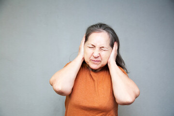 Emotional middle-aged woman on   gray background.