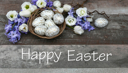 Flower arrangement with white Easter eggs in a basket and the text Happy Easter.