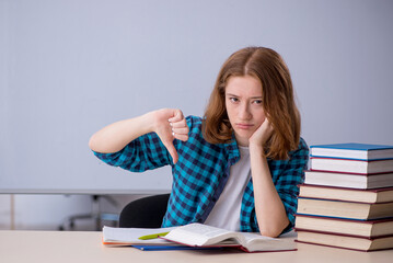 Young female student preparing for exams in the classroom