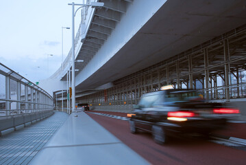 Taxi cab on Rainbow Bridge at dusk in Tokyo, Japan　夕方の東京レインボーブリッジを走るタクシー