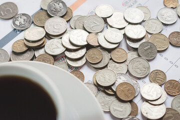 A cup of black coffee on an investor's desk with a financial report