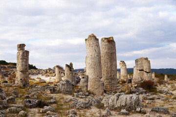 Fototapeta na wymiar ancient stone pillars Pobite Stones in Bulgaria against a cloudy sky
