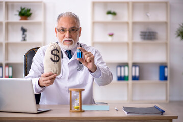 Old male doctor in remuneration concept