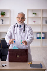 Old male doctor working in the clinic