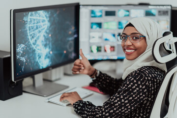 Young Afro-American modern Muslim businesswoman wearing a scarf in a creative bright office workplace with a big screen.
