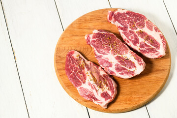 Sliced raw pork meat  with spices on wooden surface, top view