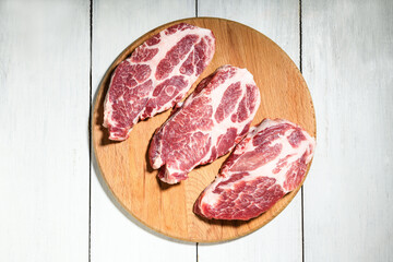 Sliced raw pork meat on wooden surface, top view