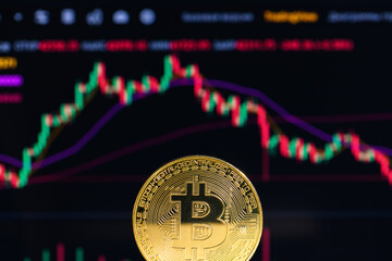 Golden bitcoin on the background of charts, close up. Crypto currency. Bitcoin mining concept