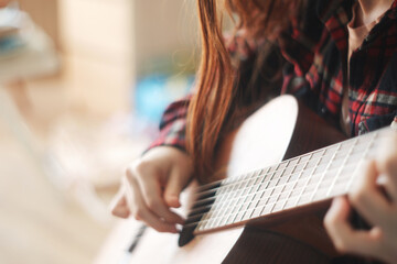 Selective soft focus, close up hands teenager girl learning to play guitar. copy space