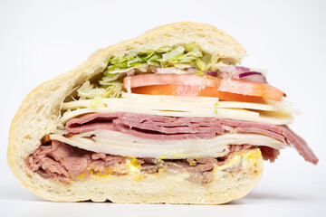 Italian sub sandwich portraying all of its ingredients on a white background