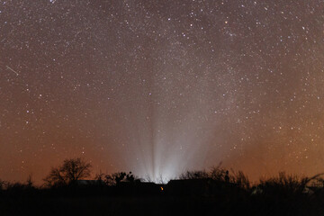 Rays of light in the boundless starry sky over the Ukrainian city