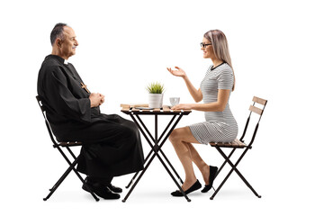 Obraz premium Priest and a young woman sitting at a cafe table and talking