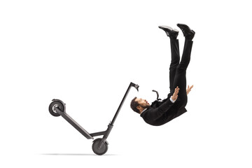 Man in a suit and tie falling from an electric scooter
