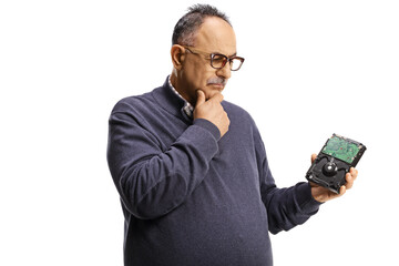 Mature man holding a computer hard drive and thinking
