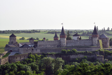 A large stone fortress with several towers against the distant horizon