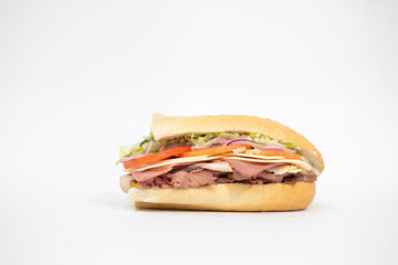 Italian sub sandwich portraying all of its ingredients on a white background