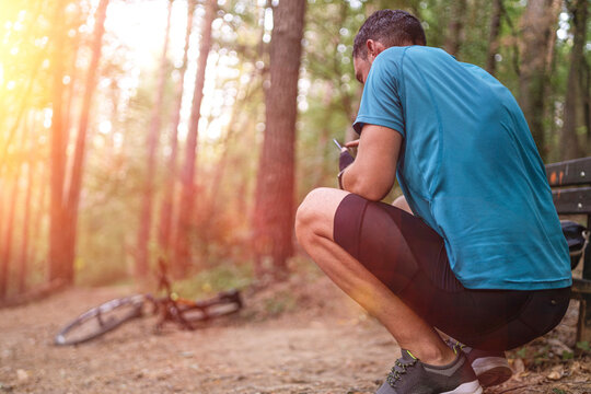 young mountain biker check his smartphone while resting