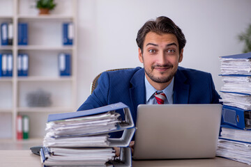 Young male employee and too much work in the office