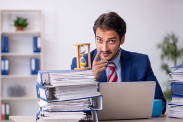 Young male employee in time management concept