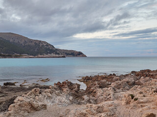 Rocks and turquoise water in Cala Agulla in Cala Ratjada at sunset. Majorca, Balearic Islands, Spain, Europe