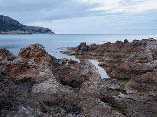 Rocks and turquoise water in Cala Agulla in Cala Ratjada at sunset. Majorca, Balearic Islands, Spain, Europe