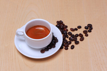 Hot espresso coffee cup and beans isolated on wooden table