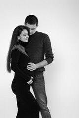 Husband hugs pregnant wife and touching belly