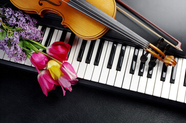 Synthesizer keyboard, violin and a bouquet of tulips. © yrafoto