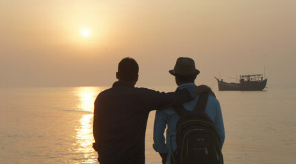 Two friends watching the sunset at Kuakata sea beach, Bangladesh