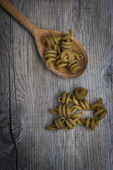 Spinach fusilli on a wooden spoon.